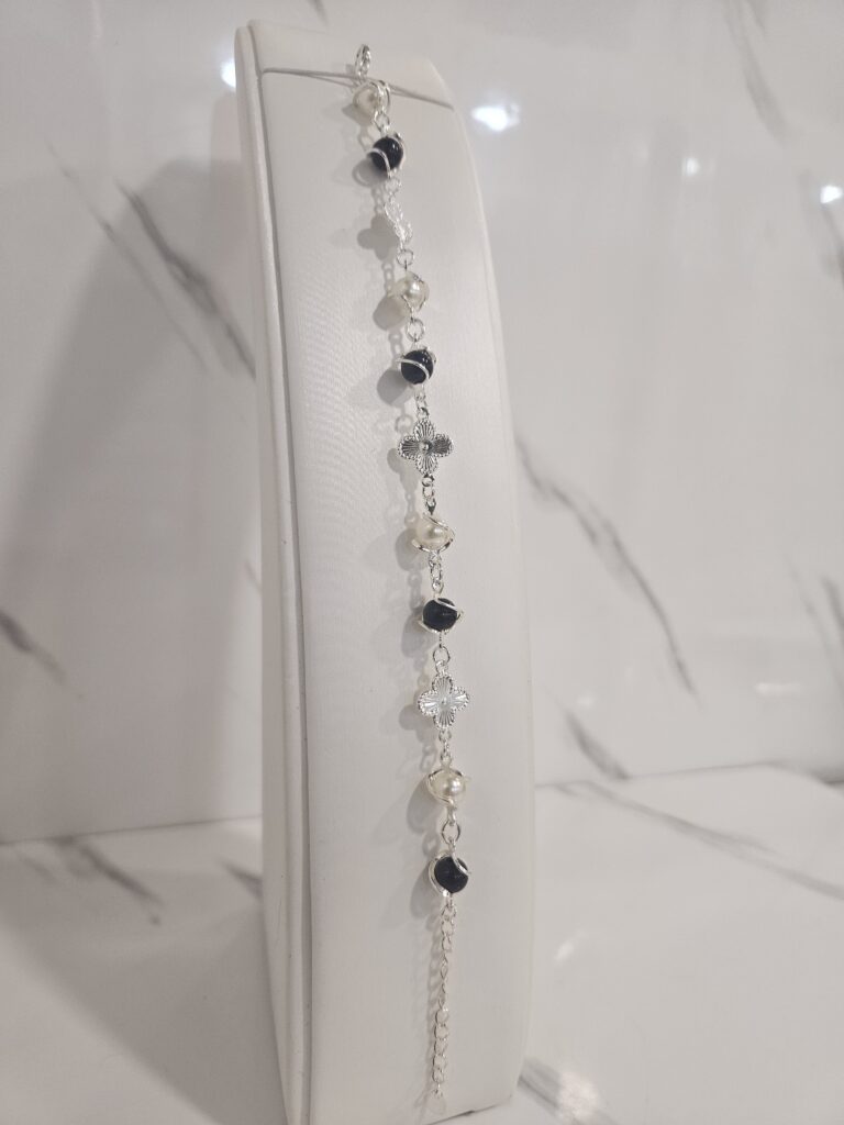 Pulsera perla negra y blanca con trébol